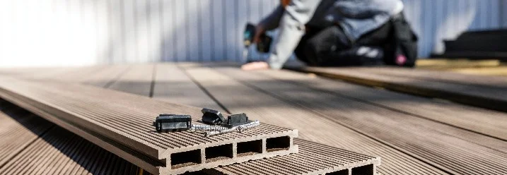 Person baut Holzterrasse mit Akkuschrauber